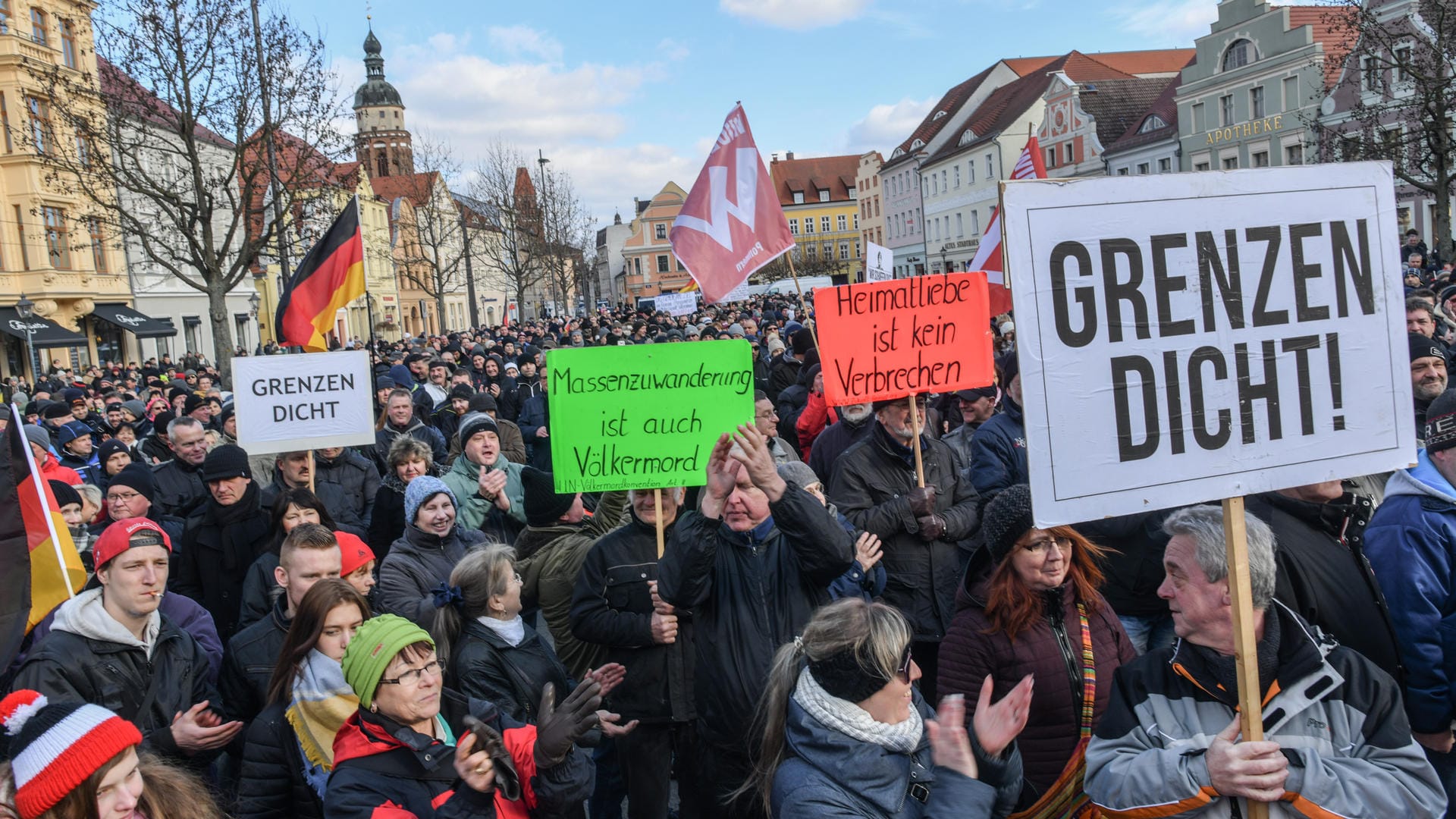 Cottbus: Demonstranten stehen auf dem Altmarkt mit Fahnen und Plakaten und protestieren gegen Zuwanderung und die Asyl-Politik der Bundesregierung. Cottbus: Demonstranten stehen auf dem Altmarkt mit Fahnen und Plakaten und protestieren gegen Zuwanderung und die Asyl-Politik der Bundesregierung.