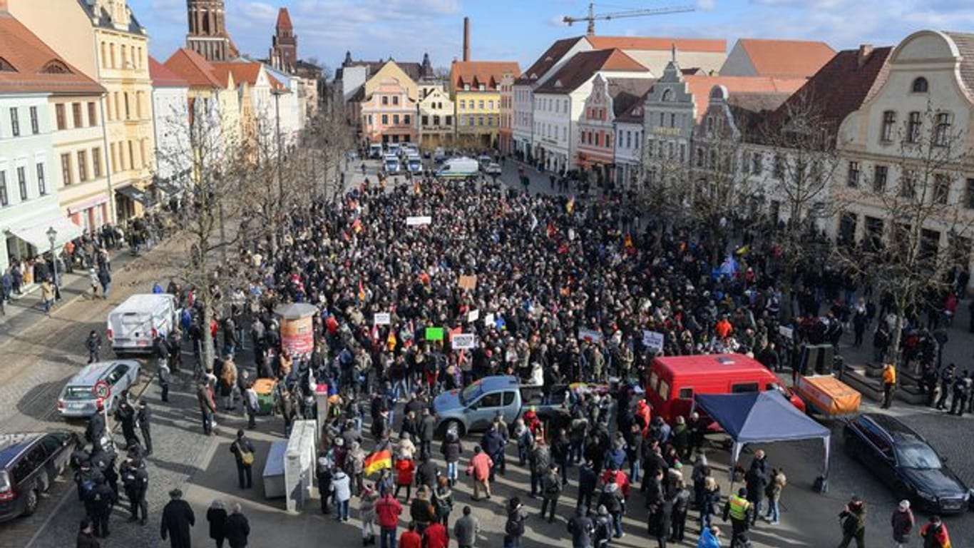 Demonstranten stehen auf dem Altmarkt in Cottbus und protestieren gegen Zuwanderung und die Asyl-Politik der Bundesregierung.