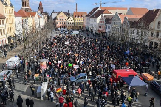 Demonstranten stehen auf dem Altmarkt in Cottbus und protestieren gegen Zuwanderung und die Asyl-Politik der Bundesregierung.