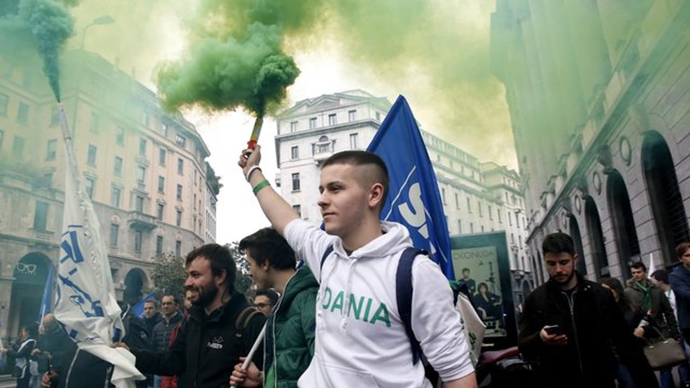 Aktivisten der rechtspopulistischen Partei Lega halten bei einer Demonstration in Mailand Rauchfackeln in die Höhe.