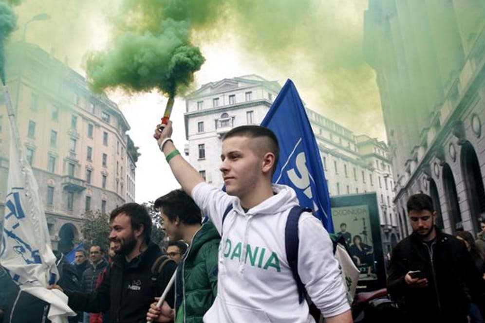 Aktivisten der rechtspopulistischen Partei Lega halten bei einer Demonstration in Mailand Rauchfackeln in die Höhe.