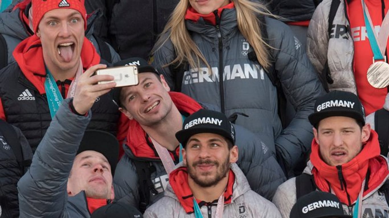 Spieler der Eishockey-Nationalmannschaft fotografieren Selfies auf der Gangway nach der Landung in Frankfurt.