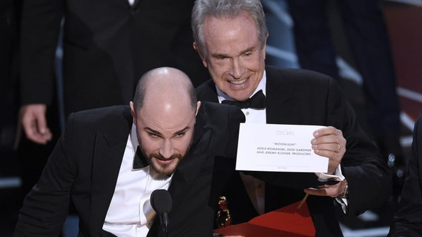 Warren Beatty zeigt den richtigen Umschlag, während "La La Land"-Produzent Jordan Horowitz (l) den wahren Gewinner verkündet: "Moonlight".
