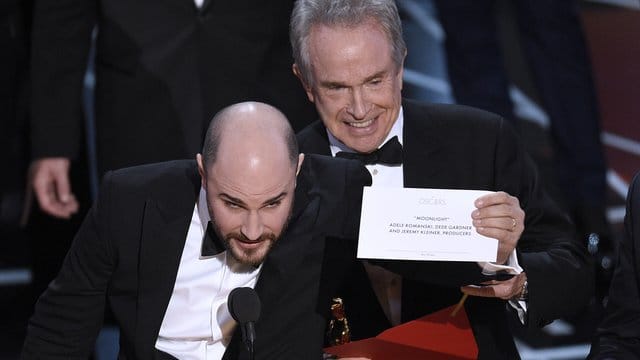 Warren Beatty zeigt den richtigen Umschlag, während "La La Land"-Produzent Jordan Horowitz (l) den wahren Gewinner verkündet: "Moonlight".