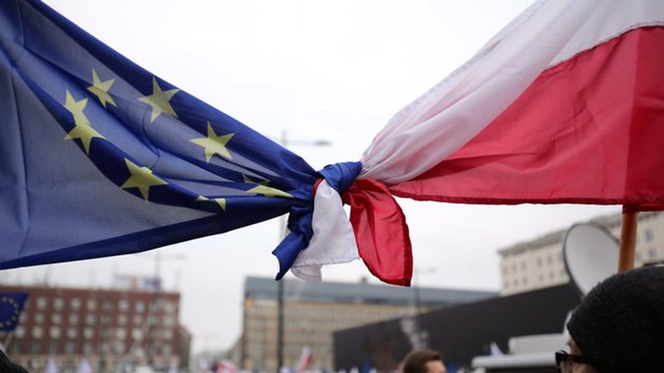 Flaggen der EU und Polens bei einer Demo in Warschau.
