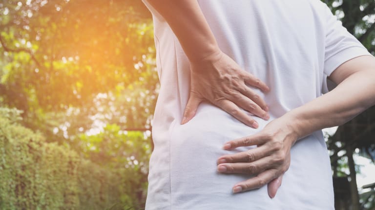 Frau mit Rückenschmerzen: Wer viel tragen muss und dabei nicht auf seine Körperhaltung achtet, riskiert neben Bandscheibenproblemen auch Arthrose.