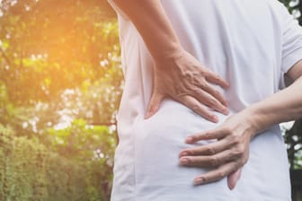 Frau mit Rückenschmerzen: Wer viel tragen muss und dabei nicht auf seine Körperhaltung achtet, riskiert neben Bandscheibenproblemen auch Arthrose.