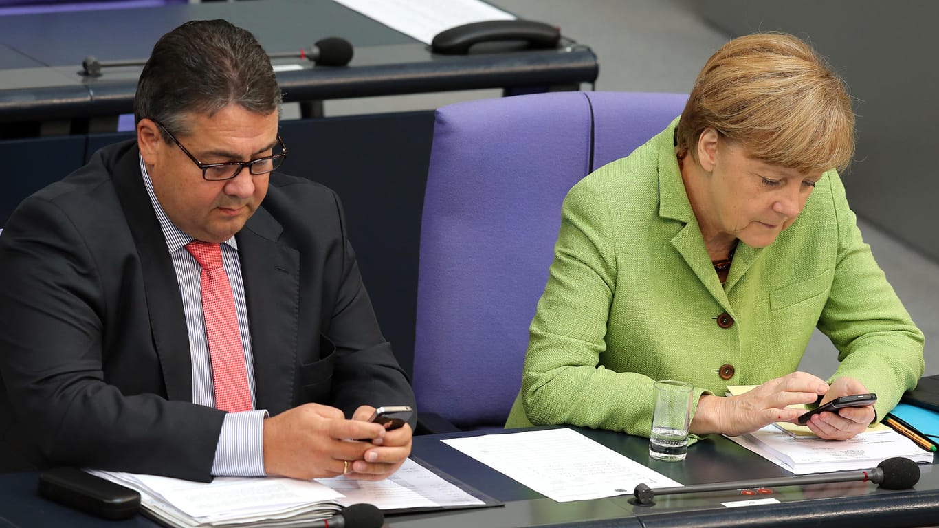 Sigmar Gabriel und Angela Merkel mit Handy im Parlament: Der Bundestag wurde bereits gehackt – nun hat es auch die Ministerien getroffen. Daten wurden vermutlich gestohlen.