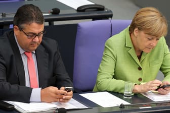 Sigmar Gabriel und Angela Merkel mit Handy im Parlament: Der Bundestag wurde bereits gehackt – nun hat es auch die Ministerien getroffen. Daten wurden vermutlich gestohlen.