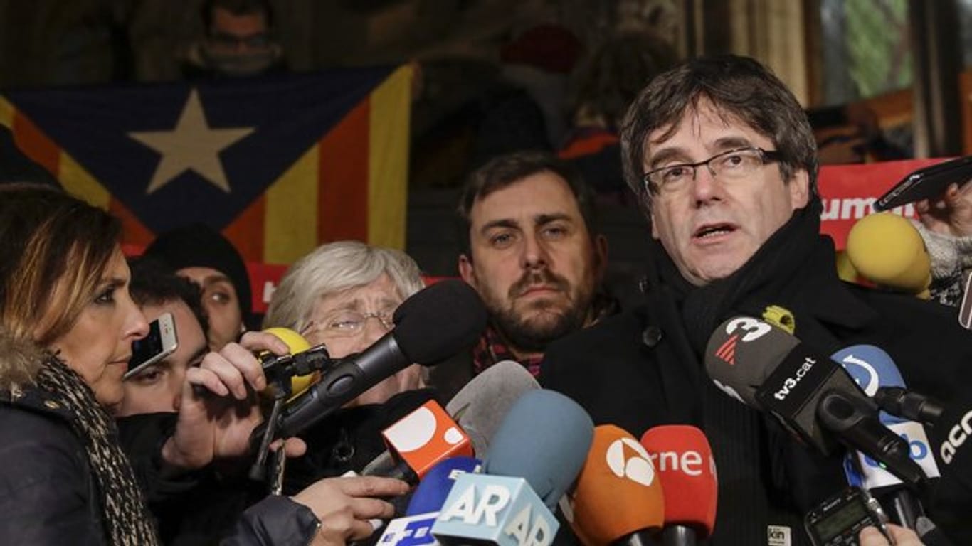 Carles Puigdemont (r), der Ex-Regierungschef von Katalonien, spricht mit Journalisten im belgischen Exil.