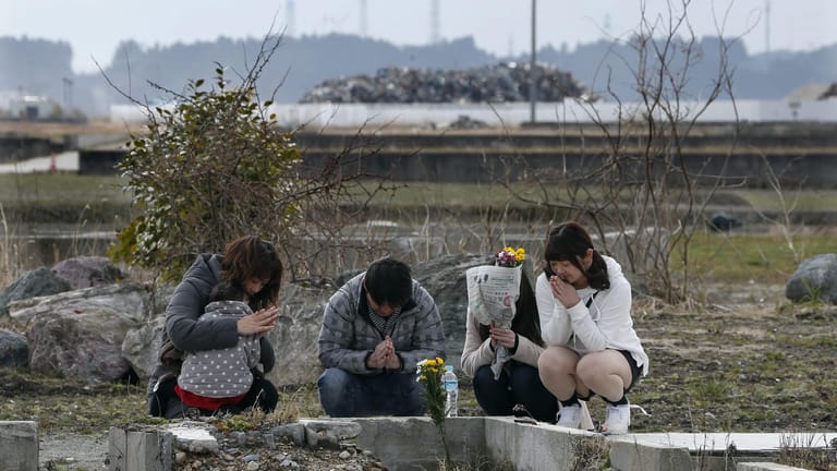 Eine Familie am Grab einer Angehörigen: Bei dem Erdbeben und Tsunami von 2011 starben mehr als 18.000 Menschen.