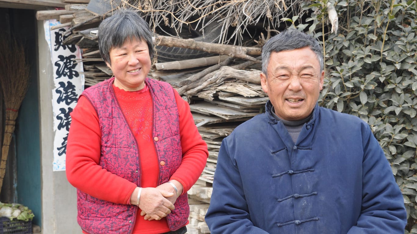 Mu Linming und seine Frau aus Rongcheng vor ihrem Haus: Sie freuen sich darauaf, dass sich nun viele Bürger besser verhalten würden.