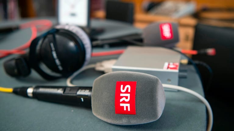 Mikrofone und ein Kopfhörer vom Schweizer Radio und Fernsehen (SRF): In einem Volksentscheid sprachen sich die Schweizer klar für die Rundfunkgebühr aus. Nun soll es im öffentlichen Rundfunk weitreichende Reformen geben.