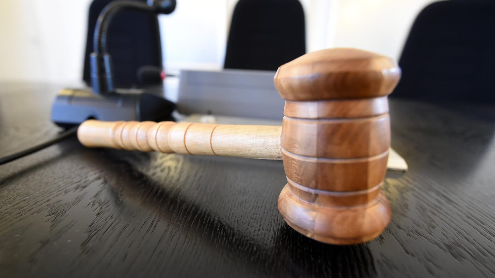 Auf einer Richterbank liegt ein Richterhammer aus Holz.