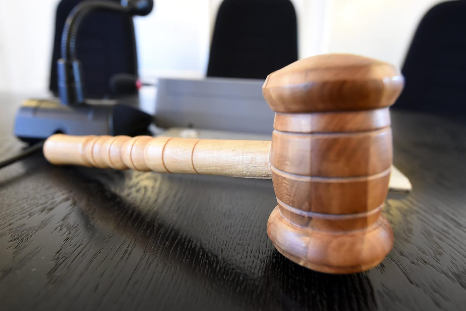 Auf einer Richterbank liegt ein Richterhammer aus Holz.