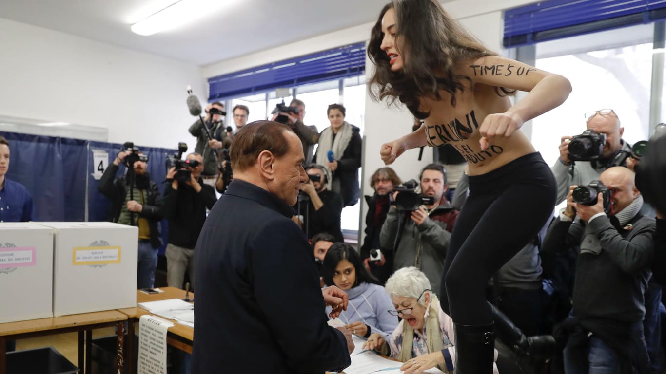 Silvio Berlusconi und eine Aktivistin: Die Zeit des umstrittenen Politikers sei abgelaufen, hat sich die Frau auf den Körper geschrieben. Wirklich?
