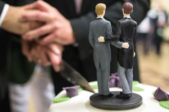 Zwei Männer schneiden eine Hochzeitstorte an: Bayern will von möglicher Klage gegen Ehe für alle abrücken.