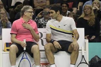 Bill Gates (l) und der Schweizer Tennisspieler Roger Federer auf dem Tennisplatz.