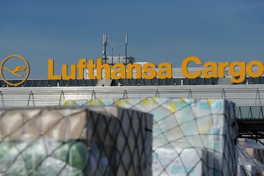 Paletten mit verpackter Fracht vor einer Halle der Lufthansa Cargo.