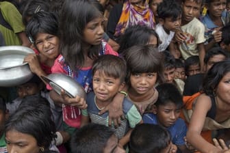 Kinder der muslimischen Rohingya-Minderheit aus Myanmar warten in einem Flüchtlingslager in Bangladesch auf Essensrationen.