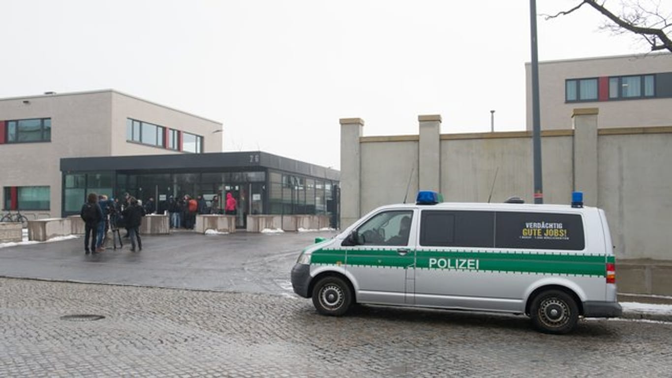 Polizeifahrzeug und Journalisten stehen vor der Justizvollzugsanstalt Dresden.