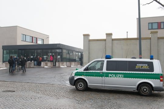 Polizeifahrzeug und Journalisten stehen vor der Justizvollzugsanstalt Dresden.