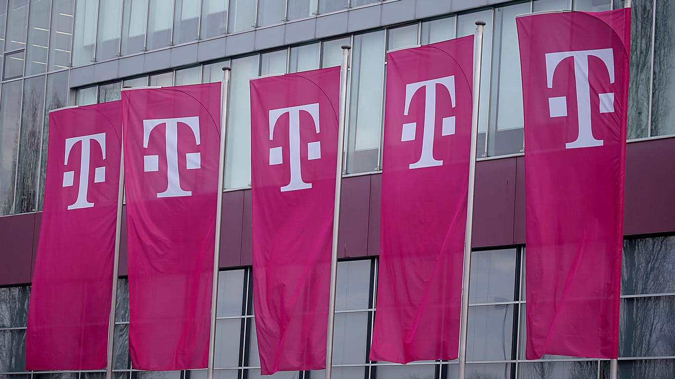Fahnen wehen vor einem Gebäude der Deutschen Telekom in Bonn: Im Streit mit der Netzwerkagentur beharrt die Telekom auf die Rechtmäßigkeit ihres Streaming-Tarifs.