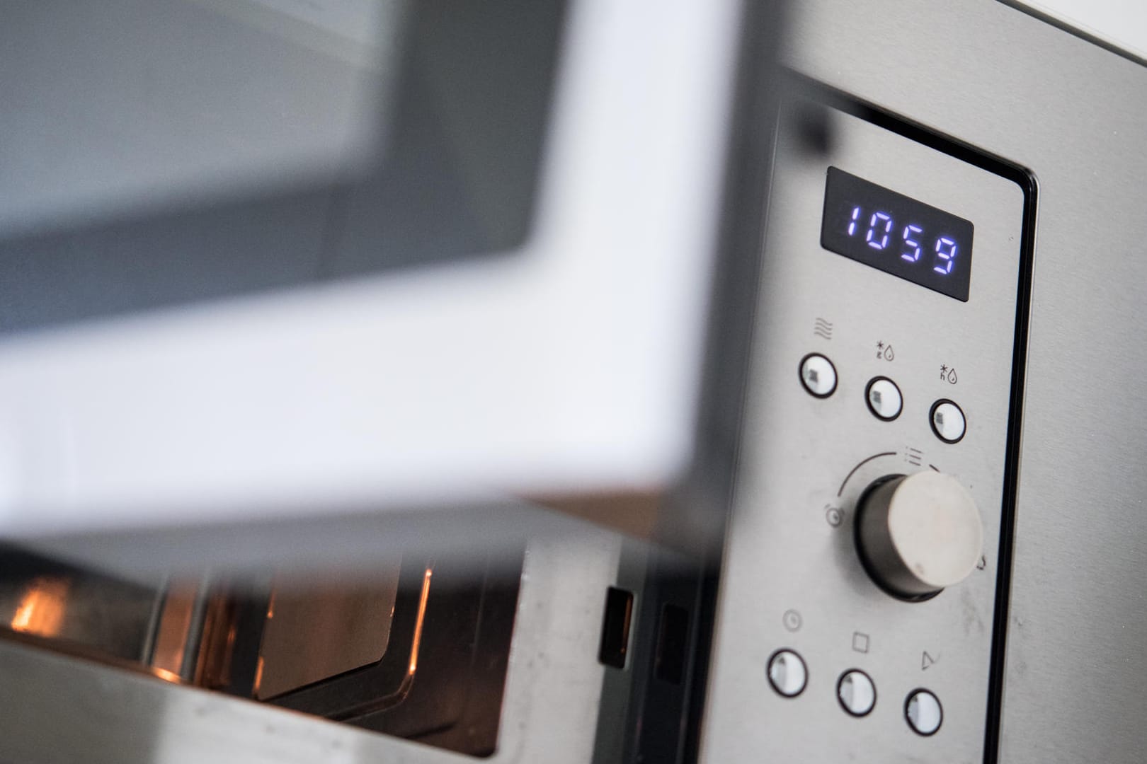 Die Uhr an einer Mikrowelle zeigt eine Uhrzeit 10:59 Uhr: Momentan gehen viele elektronische Uhren nach. Grund dafür soll ein Konflikt im Balkan sein.