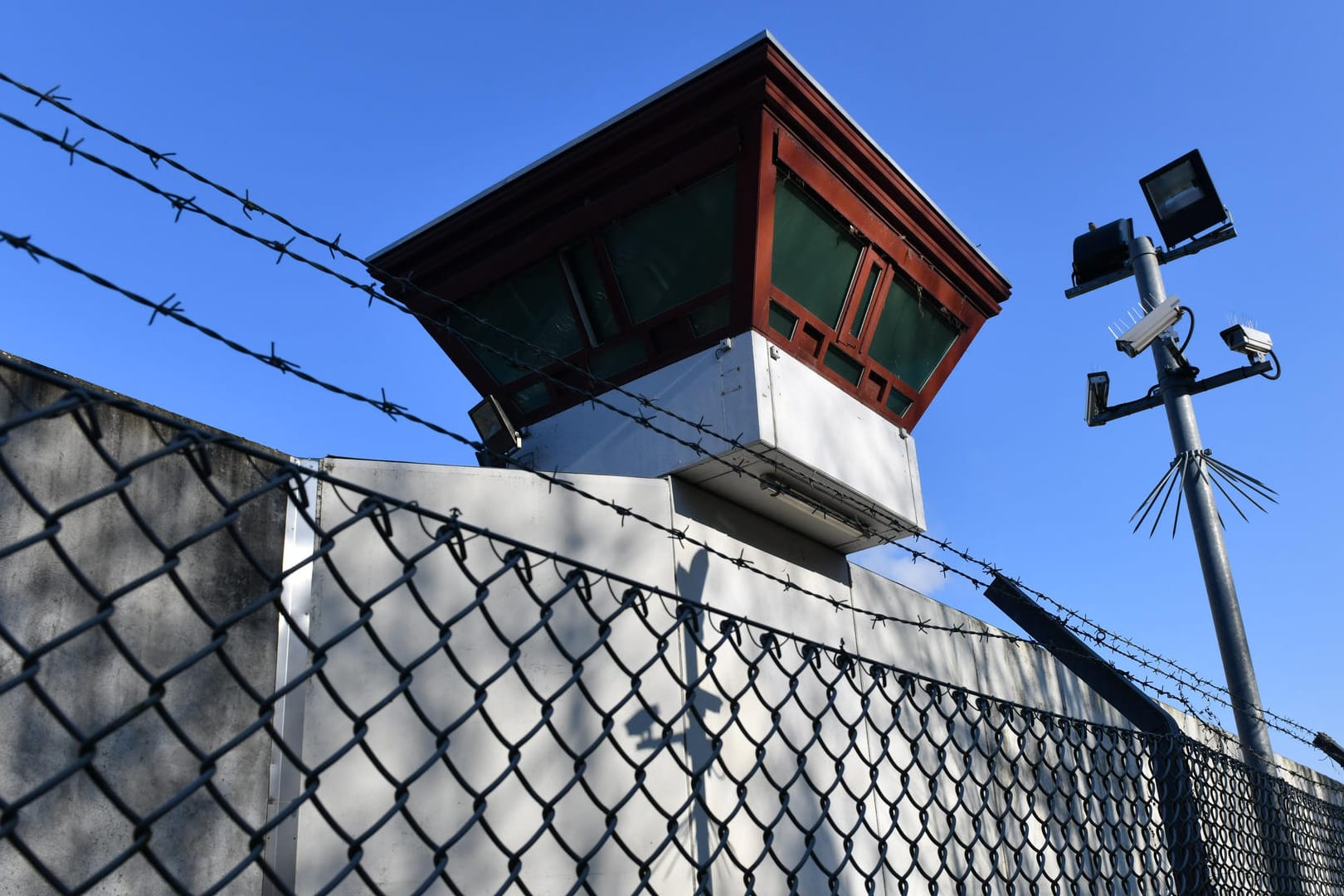 Sicherheitsleuchten und Überwachungskameras sind vor einem Gebäude auf dem Gelände der Justizvollzugsanstalt Tegel zu sehen: Knapp einen Monat nach seiner spektakulären Flucht aus dem Gefängnis in Berlin-Tegel wurde ein 24-Jähriger in Belgien festgenommen.