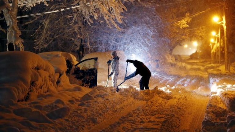 In Morristown im US-Bundesstaat New Jersey versuchen Anwohner ihr Auto vom Schnee zu befreien.