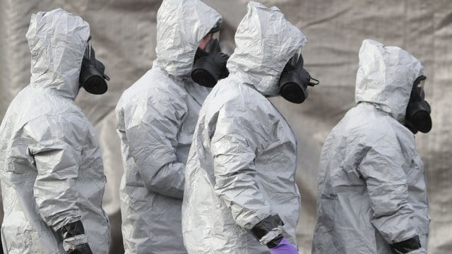 Ermittler in Schutzkleidung und Gasmasken bereiten den Abtransport eines Krankenwagens in der Nähe von Salisbury vor.