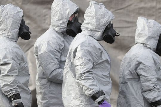 Ermittler in Schutzkleidung und Gasmasken bereiten den Abtransport eines Krankenwagens in der Nähe von Salisbury vor.