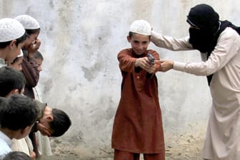 IS-Mitglied (r) zeigt Kindern den Umgang mit einer Pistole: Die Video-Botschaften von Dschihadisten.