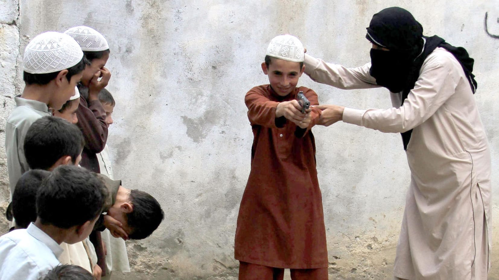 IS-Mitglied (r) zeigt Kindern den Umgang mit einer Pistole: Die Video-Botschaften von Dschihadisten.