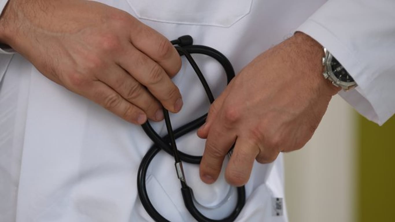 Ein Arzt hält ein Stethoskop in der Hand.