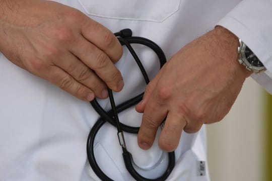 Ein Arzt hält ein Stethoskop in der Hand.