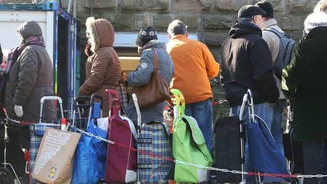 Warten auf Nahrung: Kunden der Essener Tafel stehen mit ihren Einkaufstrolleys vor der Ausgabestelle.