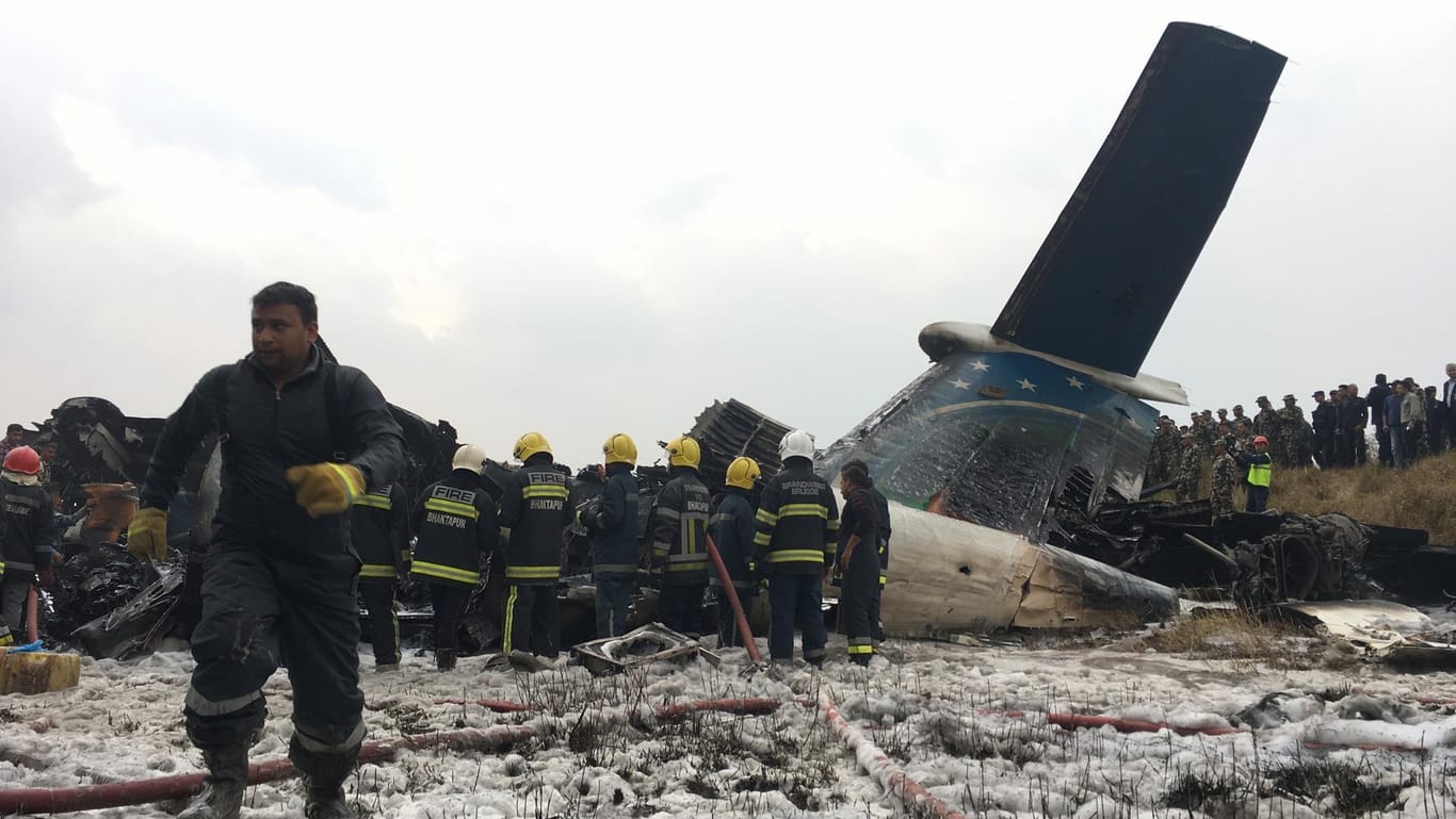 Rettungskräfte arbeiten am Wrack des abgestürzten Flugzeugs.