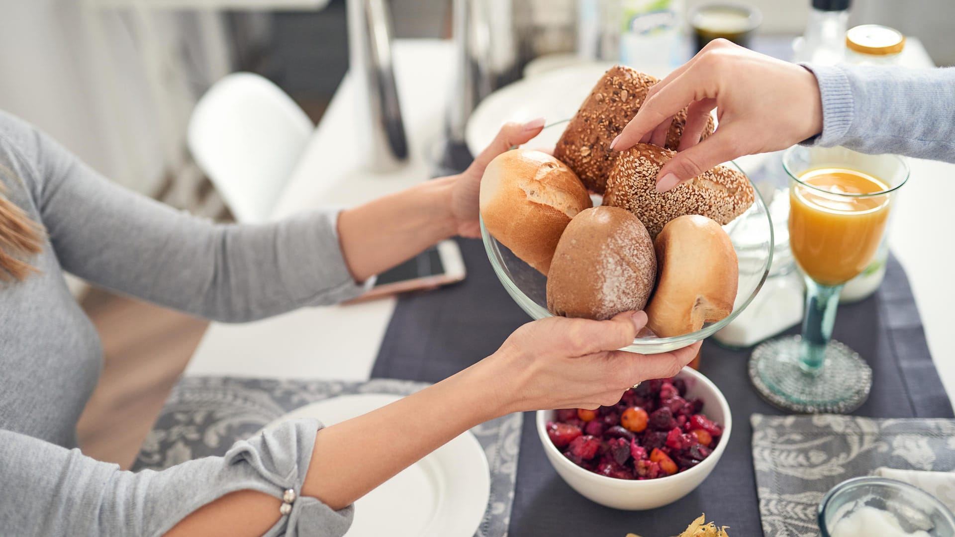 Zwei Menschen frühstücken: Ein süßes Frühstück gibt zwar kurzfristig einen Energieschub, führt mittelfristig aber zu Heißhungerattacken.