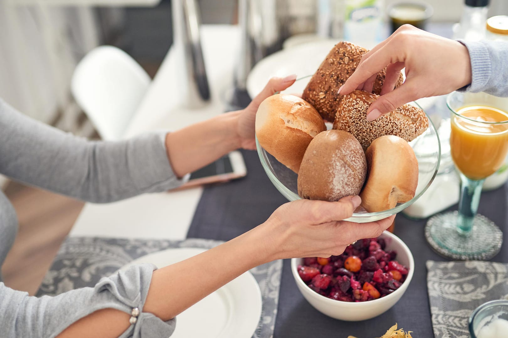 Zwei Menschen frühstücken: Ein süßes Frühstück gibt zwar kurzfristig einen Energieschub, führt mittelfristig aber zu Heißhungerattacken.