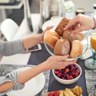 Zwei Menschen frühstücken: Ein süßes Frühstück gibt zwar kurzfristig einen Energieschub, führt mittelfristig aber zu Heißhungerattacken.