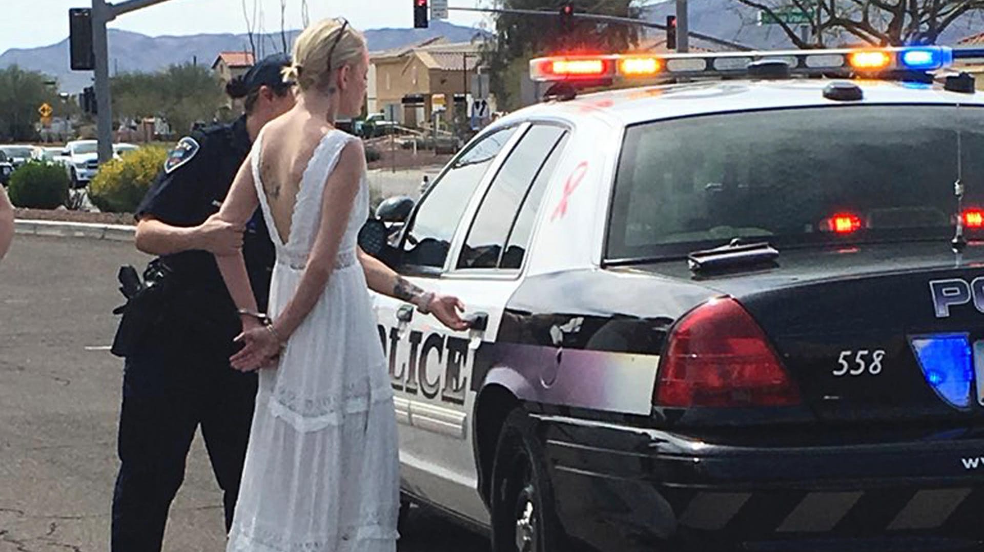 Eine US-amerikanische Polizistin führt eine Braut in Handschellen ab: Die Braut soll unter Drogeneinfluss einen Unfall verursacht haben. Eine US-amerikanische Polizistin führt eine Braut in Handschellen ab: Die Braut soll unter Drogeneinfluss einen Unfall verursacht haben.