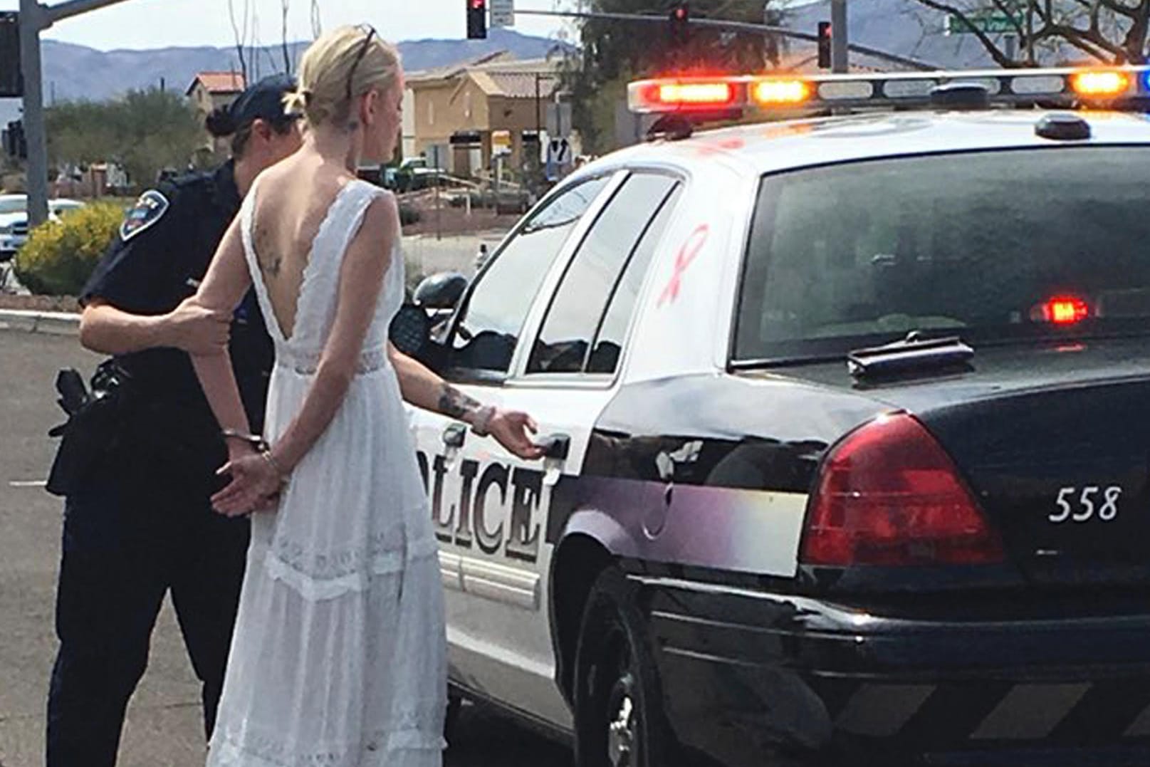 Eine US-amerikanische Polizistin führt eine Braut in Handschellen ab: Die Braut soll unter Drogeneinfluss einen Unfall verursacht haben.