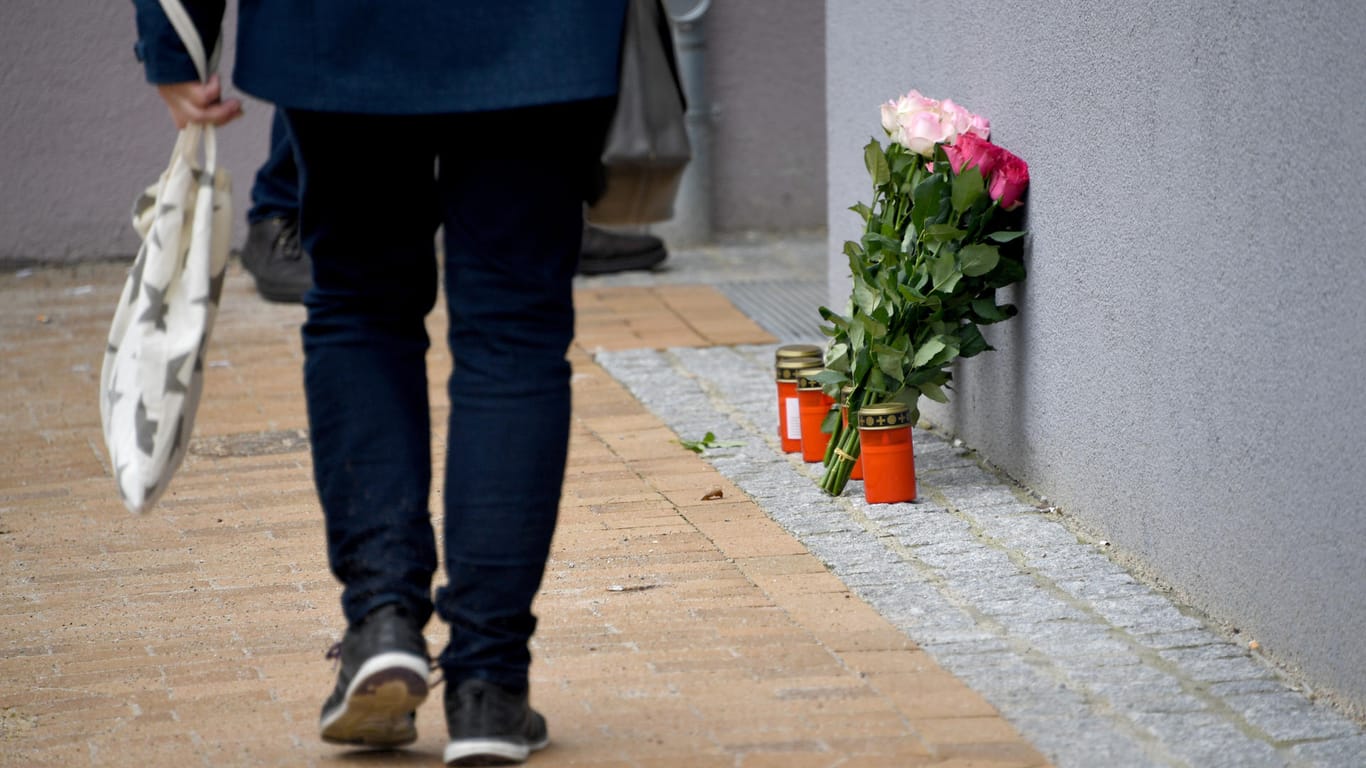 Der Tatort in Flensburg: Blumen und Grablichter stehen an dem Mehrfamilienhaus, in dem eine 17-Jährige erstochen wurde.