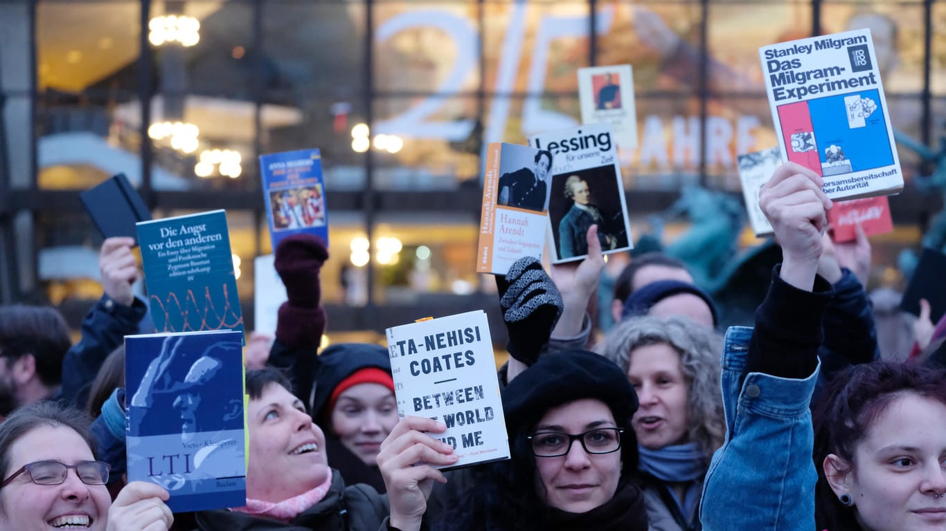 Protestaktion gegen rechte Verlage auf der Leipziger Buchmesse: Protestierende halten Bücher nach oben.