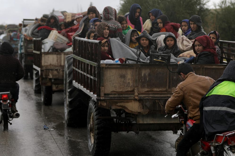 Fliehende Menschen sitzen zusammengedrängt auf einem Lastwagen, der sie aus Afrin bringt.
