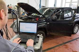 Kfz-Meister lädt ein Software-Update für das Steuergerät Motorelektronik auf einen VW: Zwei Drittel der Deutschen wollen Nachrüstungen an ihrem Dieselauto nicht selbst zahlen.