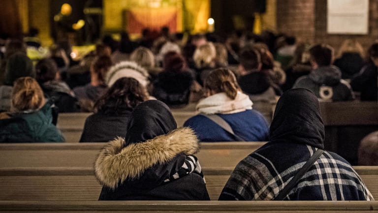 Zwei Frauen mit Kopftüchern sitzen bei einer Gedenkfeier in der Nikolaikirche nach dem Tod einer 17-Jährigen: Debatte nach Bluttaten von Migranten.