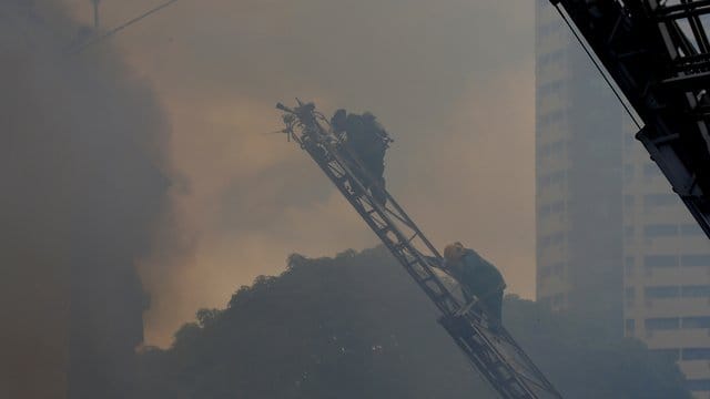 Dichter Qualm hüllt die Gegend um das brennende Hotel in Manilas Touristenbezirk Ermita ein. Dichter Qualm hüllt die Gegend um das brennende Hotel in Manilas Touristenbezirk Ermita ein.