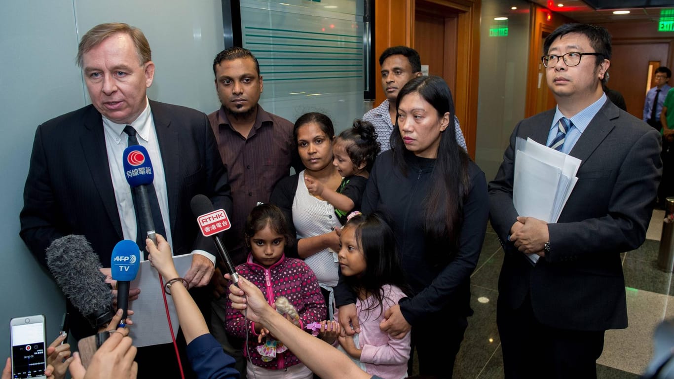 Barrister Robert Tibbo (left) and lawyer Jonathan Man (right) with "Snowdens Guardian Angels": Supun Thilina Kellapatha (2nd L with daughter Sethumdi), Nadeeka Dilrukshi Nonis (3rd Left with son Dinath), Ajith Puspa (3rd R),Vanessa Mae Rodel (2nd R with daughter Keana).